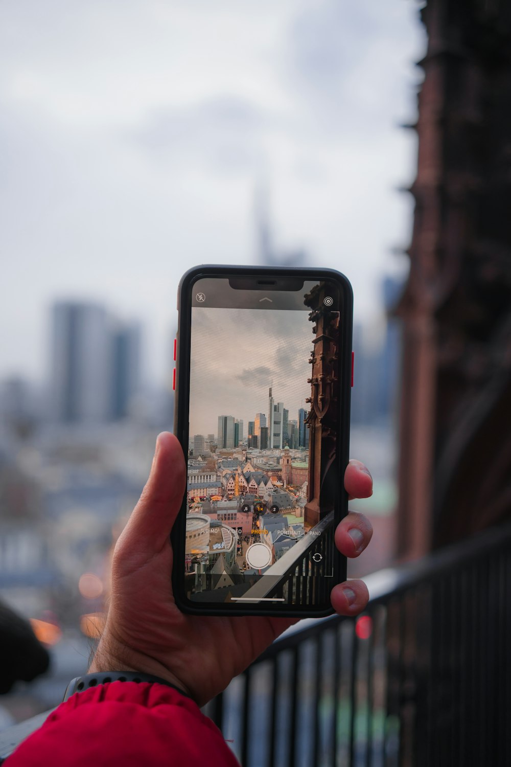 Photographie sélective de mise au point d’une personne prenant une photo de la ville