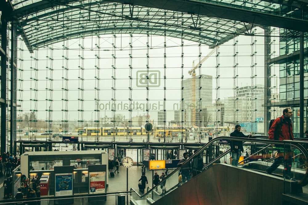 people walking inside building with escalators