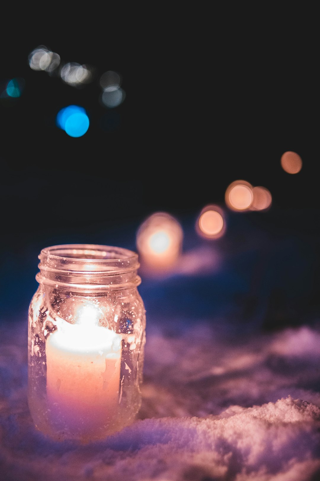 lit candle inside mason jar