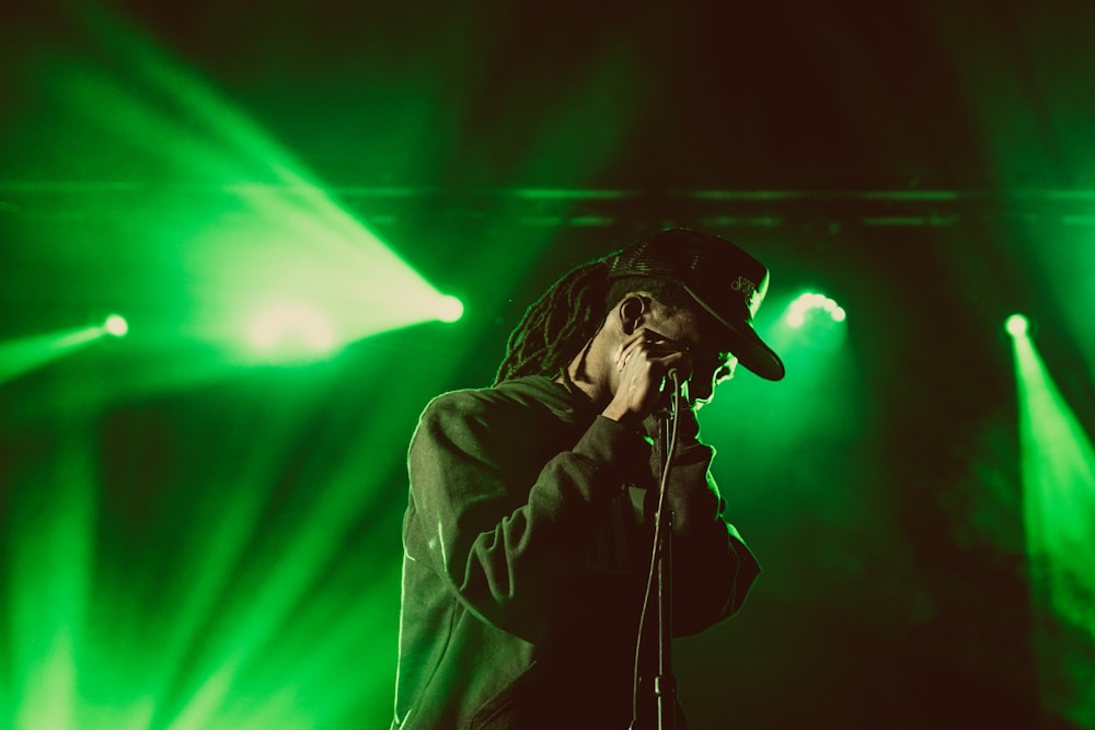 man holding microphone under green light