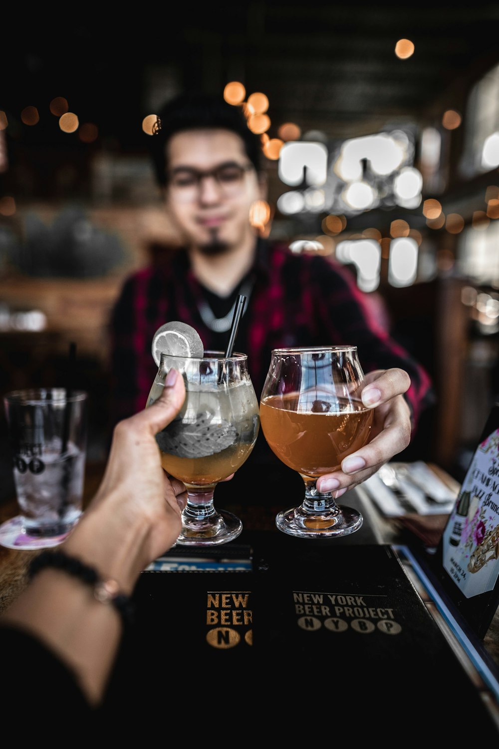 man holding clear short stem wine glass