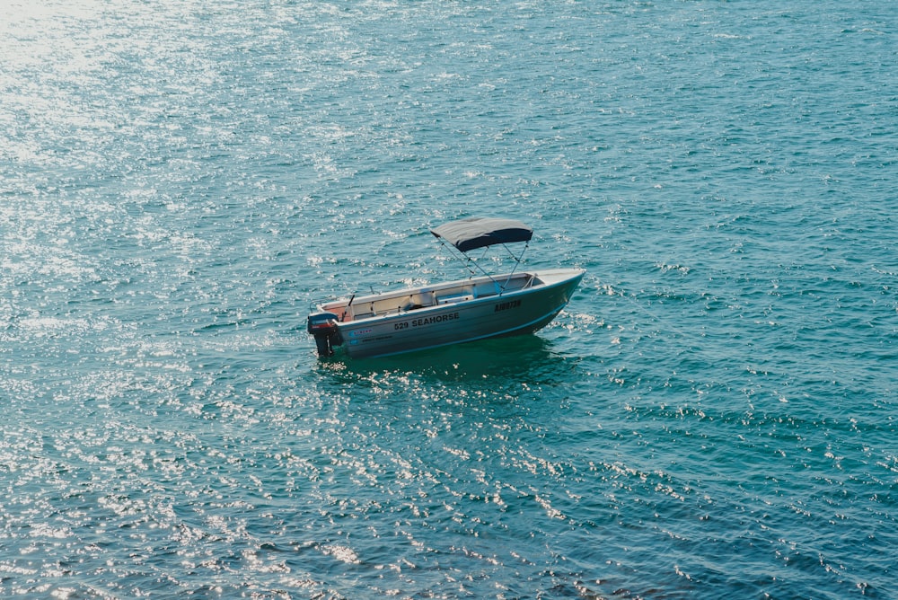 a small blue boat in the middle of the ocean