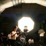 A person adjusting studio lights in a creative video shoot.