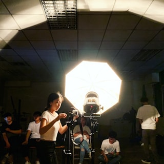 A professional photographer adjusting lighting equipment in a studio setting.