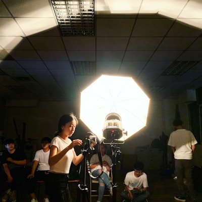 A professional photographer adjusting lighting equipment in a studio setting.