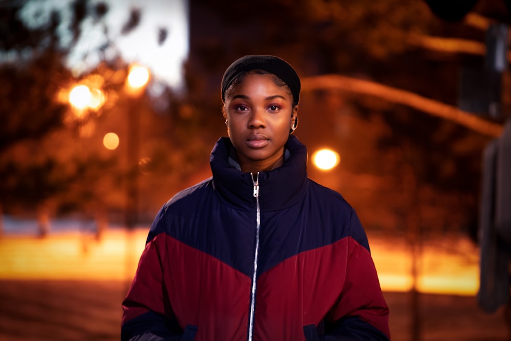 femme portant une veste zippée rouge et noire debout