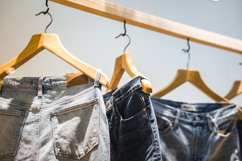 three blue denim bottoms in hangers