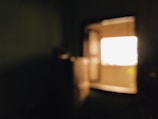 A nighttime shot of a warmly lit room seen through a crystal-clear window.