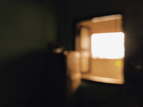 A soft-focus photograph of a sunlit window corner with delicate shadows and warm light.