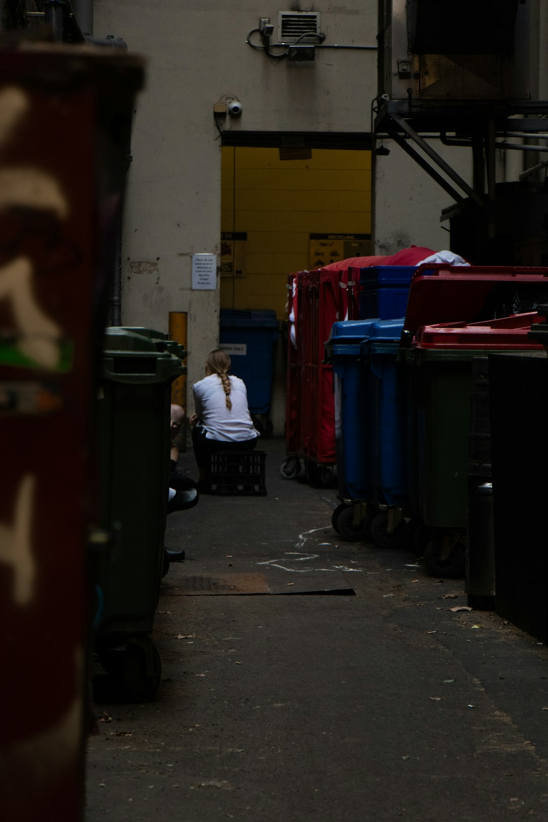 sitting person beside container