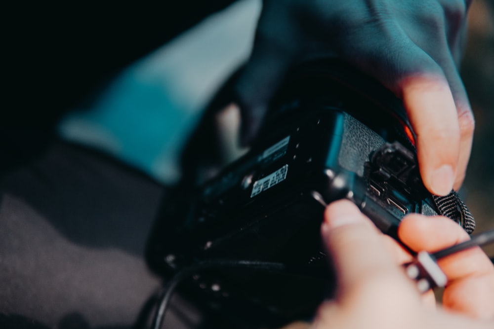 selective focus photography of person holding black camera