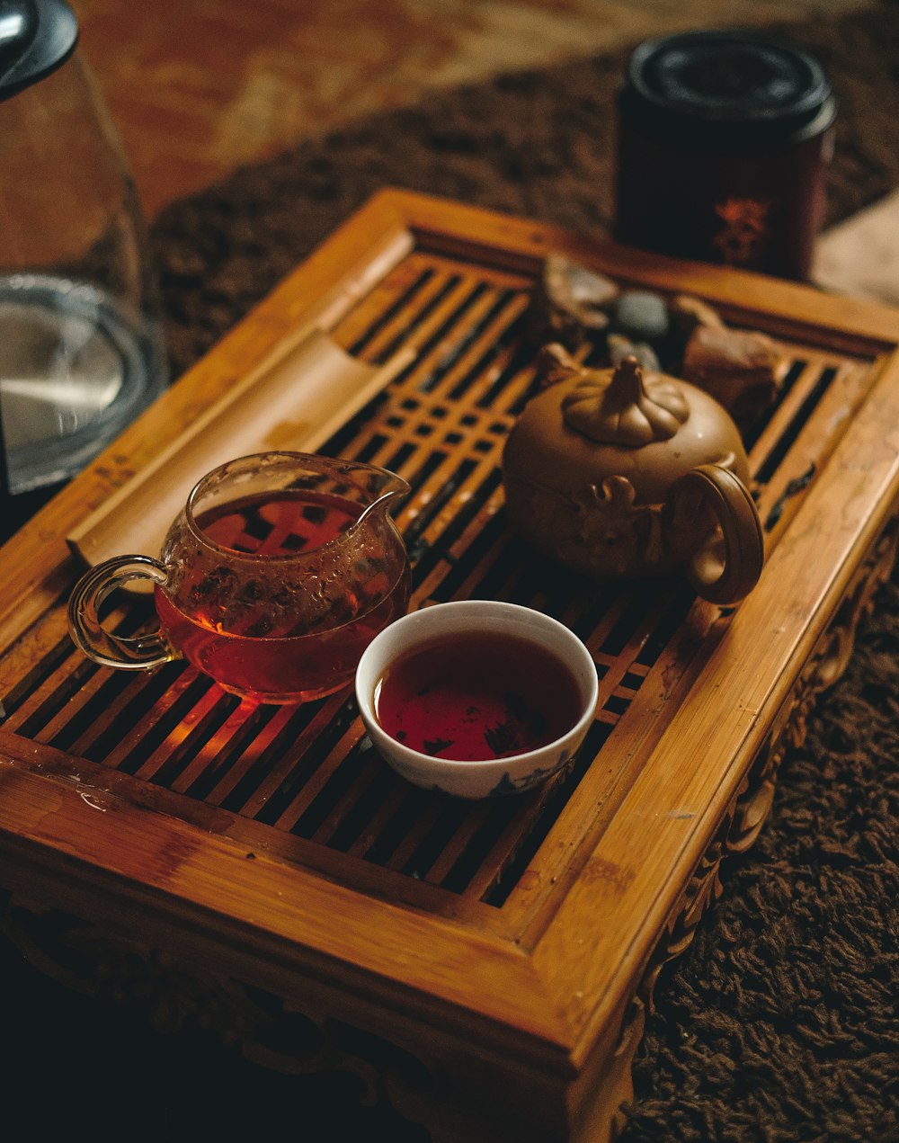 Selektive Fokusfotografie einer Tasse einer Schüssel neben einer braunen Teekanne