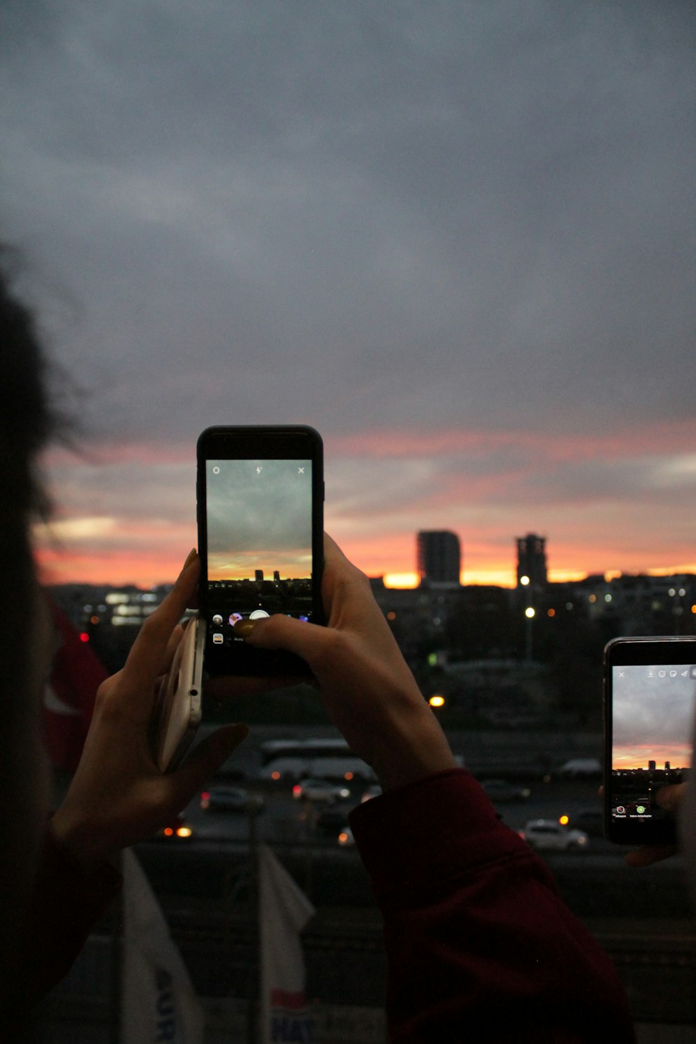 Selektive Fokusfotografie einer Person, die während der goldenen Stunde ein Foto von der Stadt macht