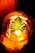 A green leaf is placed inside a glowing, orange light bulb, creating a striking juxtaposition between nature and technology. The leaf is centrally positioned, with its serrated edges clearly visible. The warm glow from the bulb enhances the details of the leaf, casting intricate shadows.