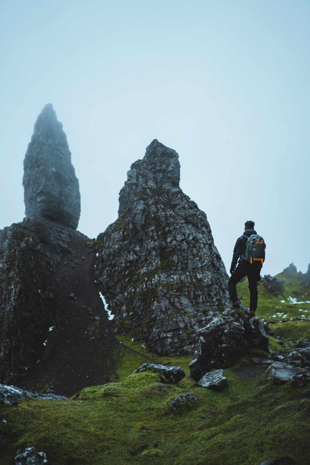 man standing on gray rock