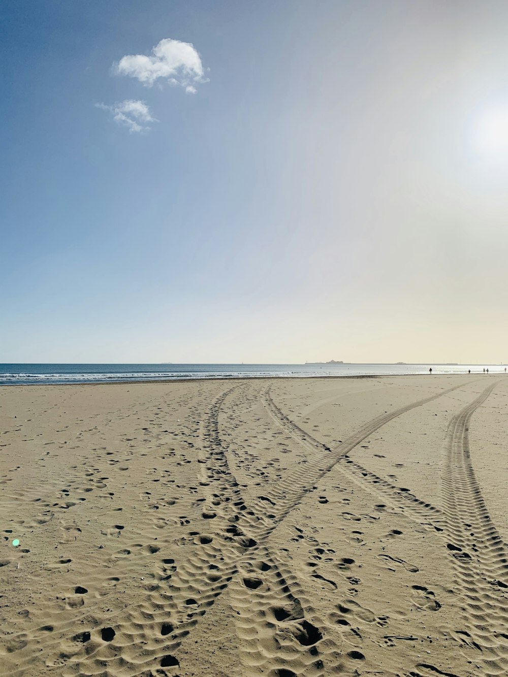 vehicle wheel mark on sand during daytime