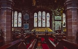 A serene interior view of a beautifully restored church with stained glass windows and comfortable seating for relaxation.