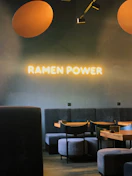 Warm, inviting interior of Kumo Ramen with wooden tables and soft lighting.