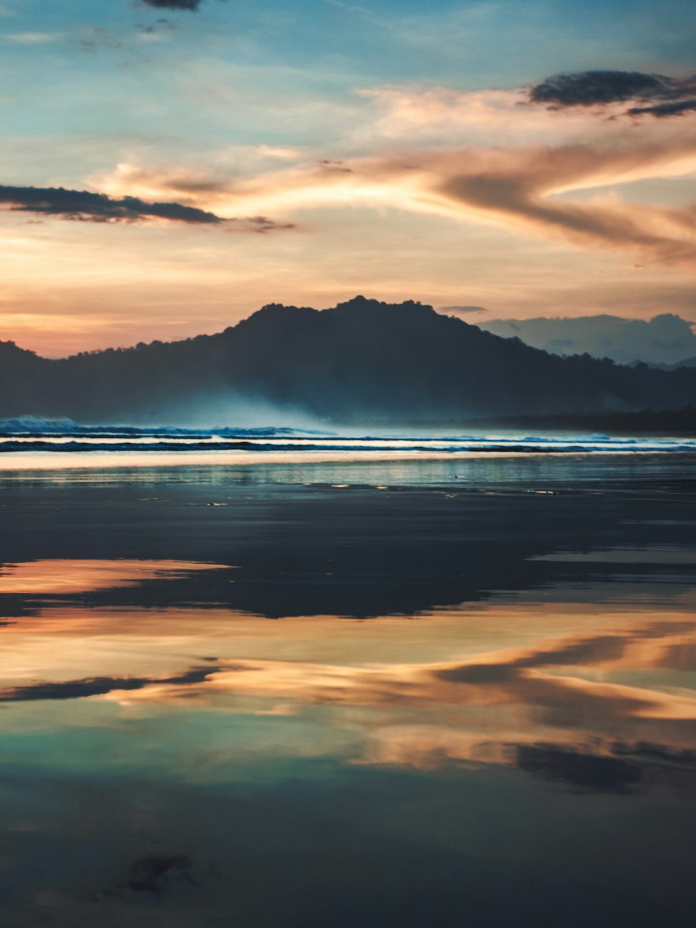 silhouette of mountains under cloudy sky