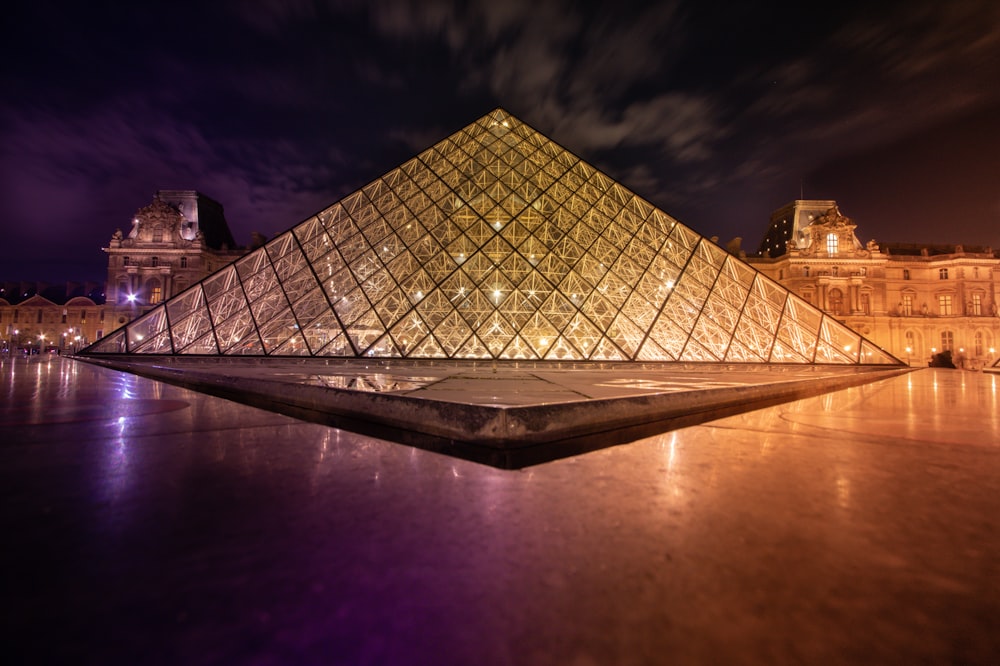 clear glass pyramid near buildings during night