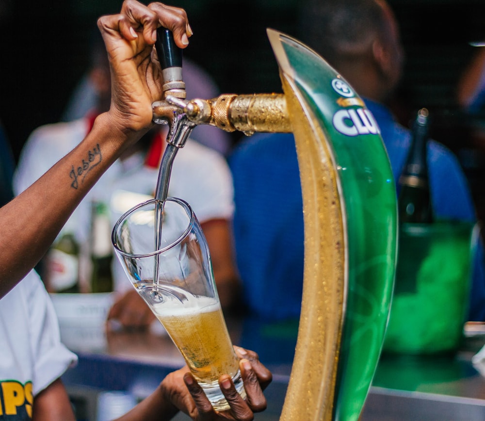 person pouring on beer keg