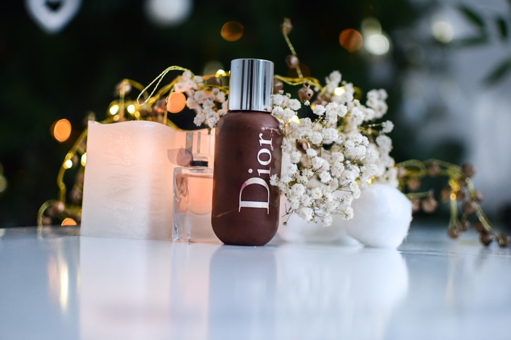 brown dior bottle beside flowers