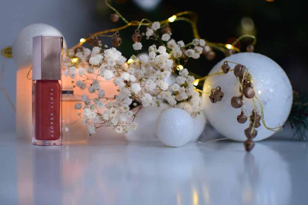 brown and gray cosmetic bottle beside flower