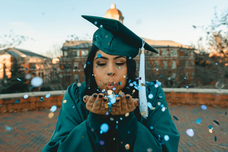 A law graduate holding a diploma, framed against a bright campus backdrop