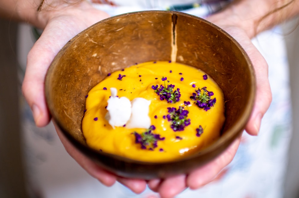 a person holding a bowl of food in their hands