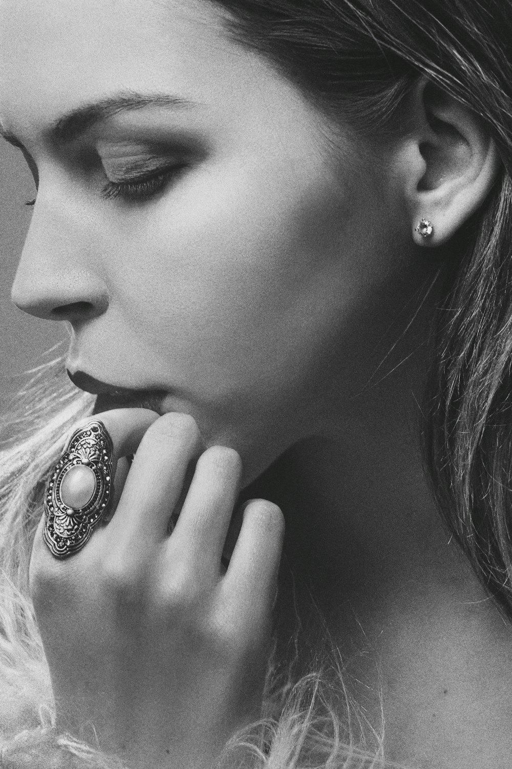 a black and white photo of a woman wearing a ring