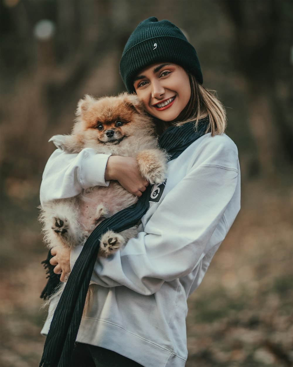 selective focus photography of girl carrying brown puppy