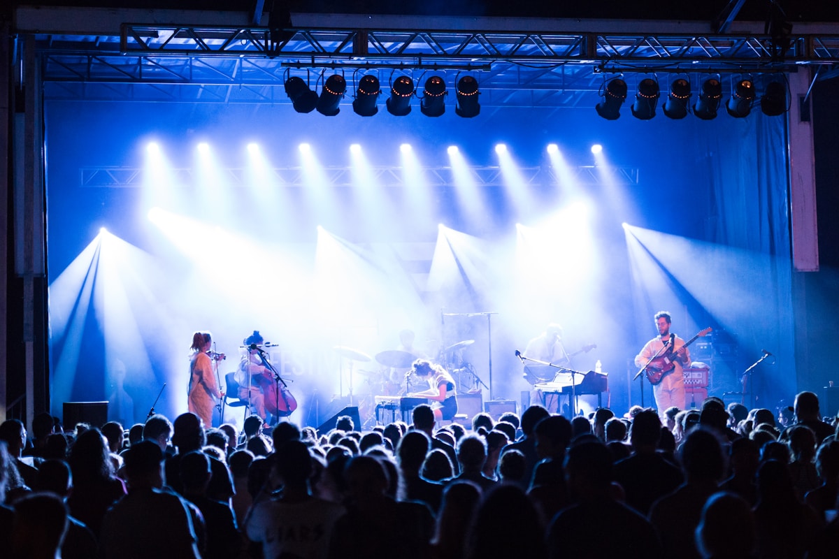 Band performing on a lit stage at night, similar to evening sets at Sisters Folk Festival venues in Sisters Oregon