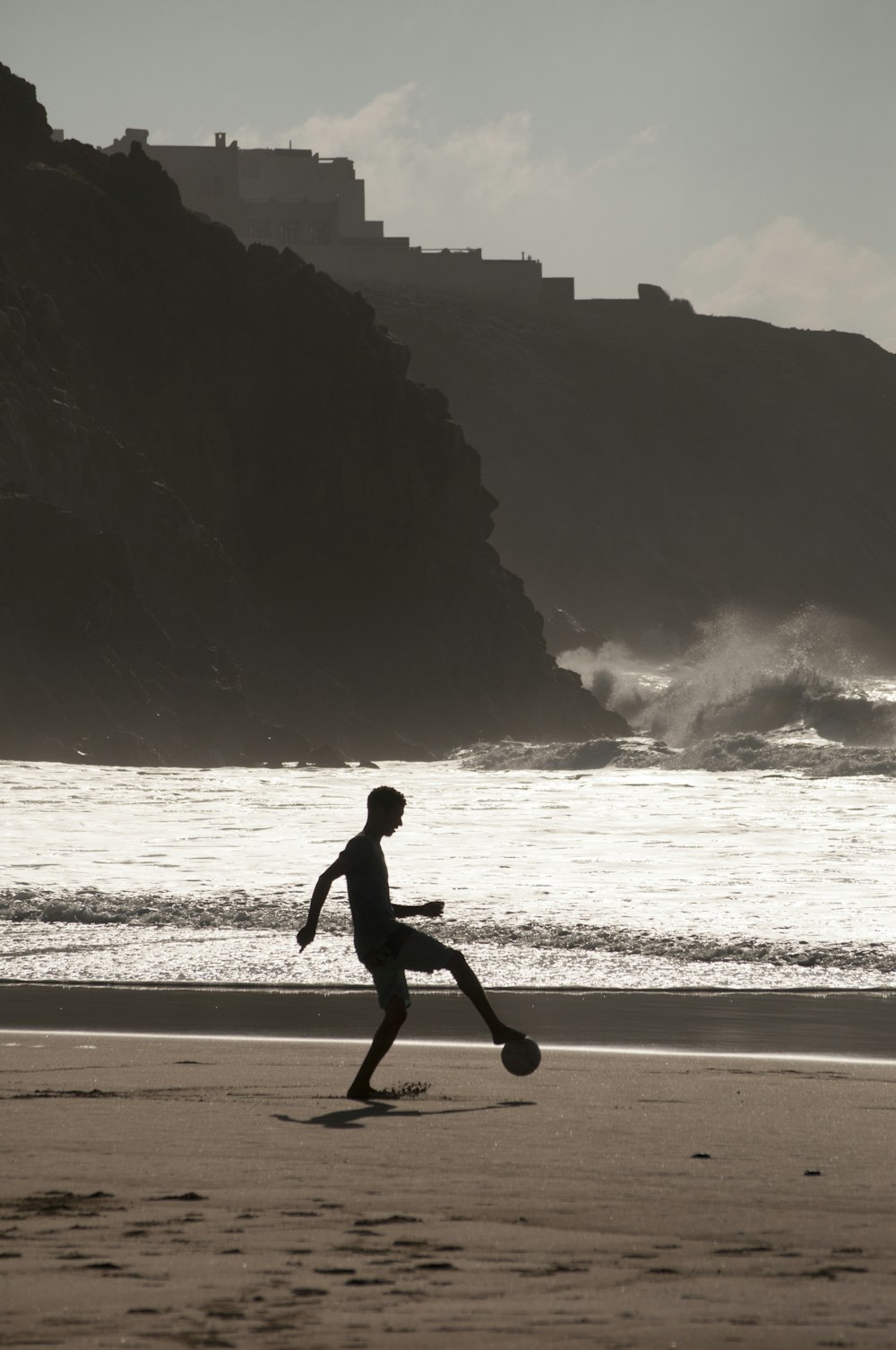 man playing soccer on shore