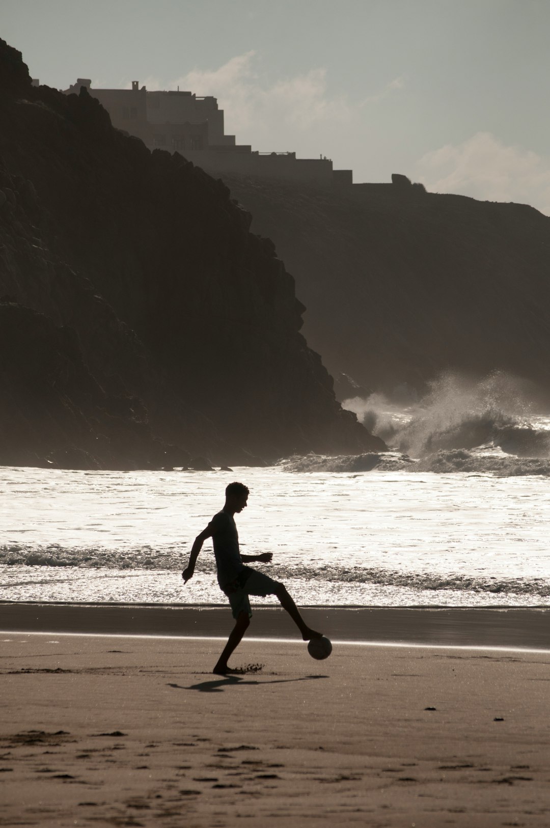 man playing soccer on shore