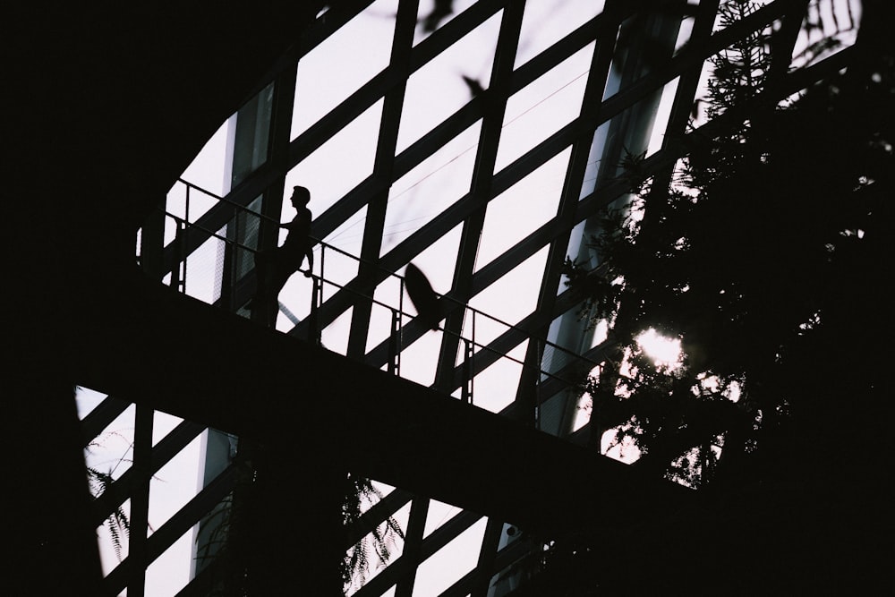 a man standing on a balcony next to a tall building