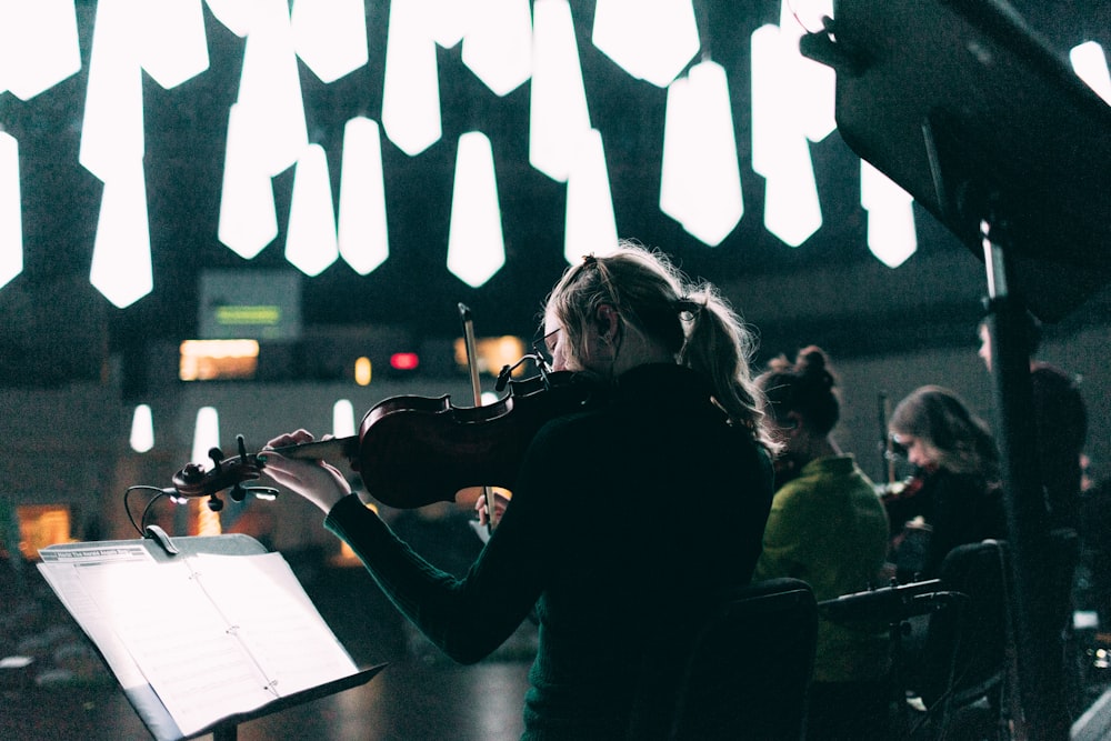 photography of woman plying violin