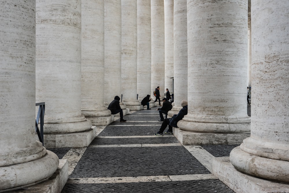 photography of people sits beside concrete post