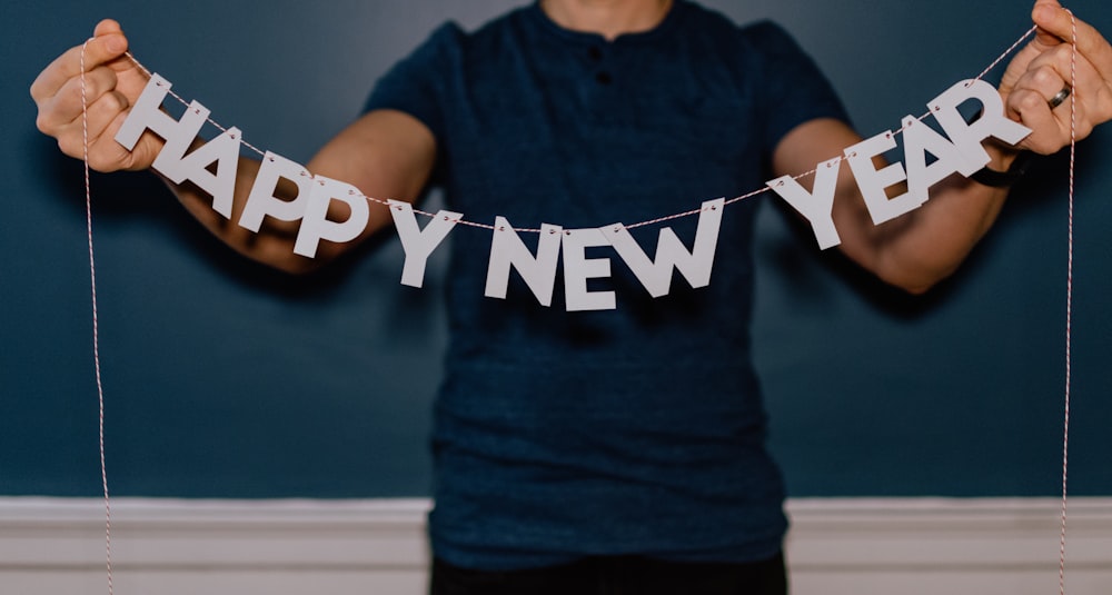 person holding happy new year decor