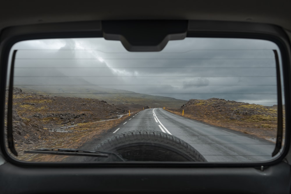 a view of a road through a rear view mirror