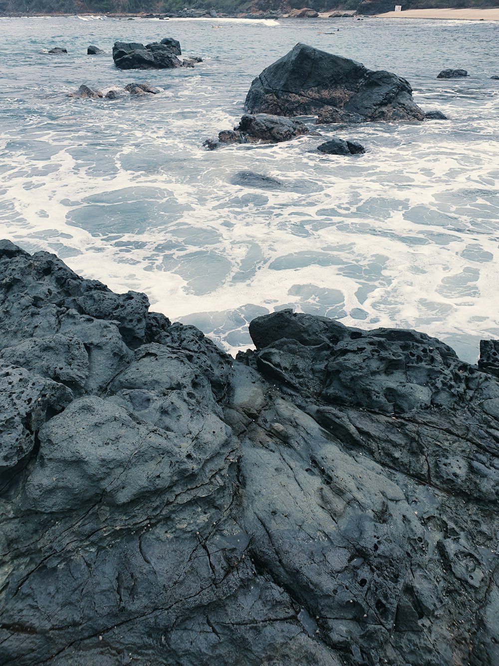 a person sitting on a rock near the ocean