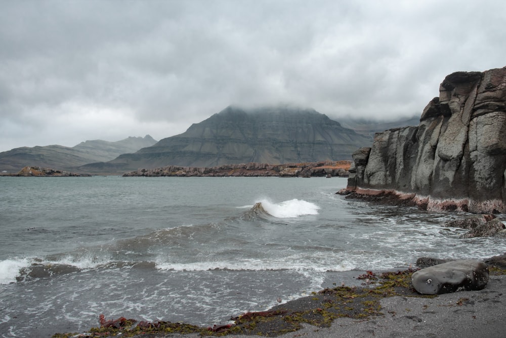 photography of seashore and mountain during daytime
