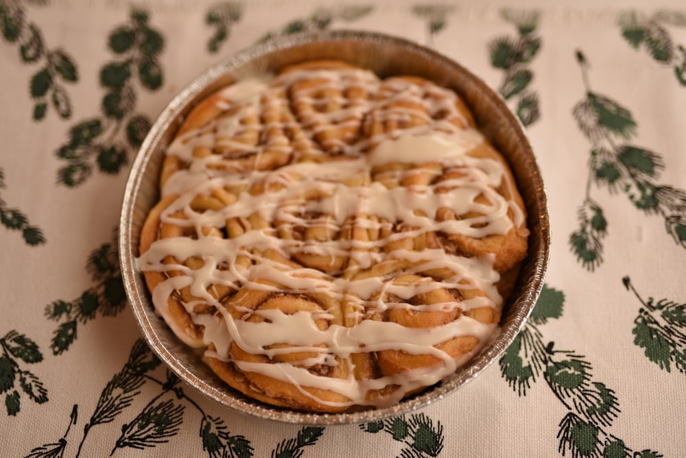 a pan filled with cinnamon rolls covered in icing