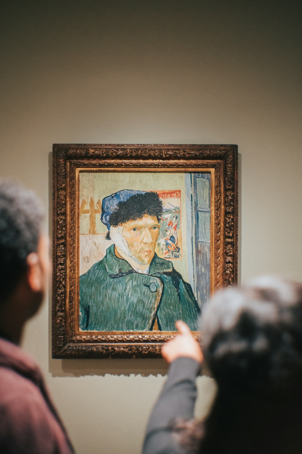 duas pessoas em pé perto de Vincent Van Gogh Autorretrato com orelha enfaixada