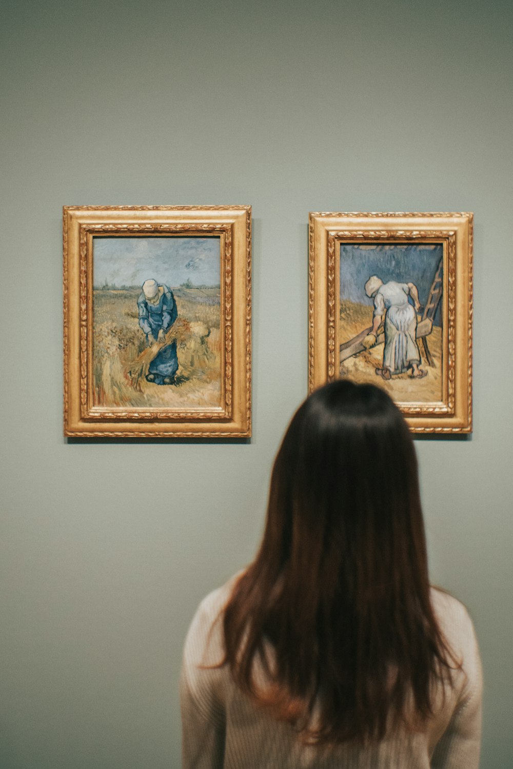 woman standing near Peasant Woman Binding Sheaves After Millet painting by Vincent Van Gogh