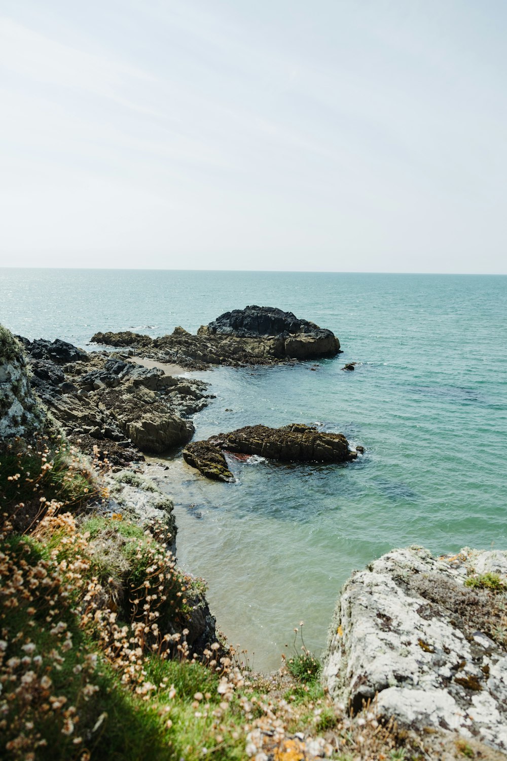 a body of water sitting next to a rocky shore