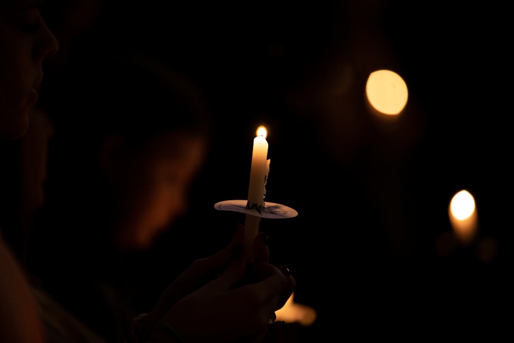 person holding lighted candle during nighttime