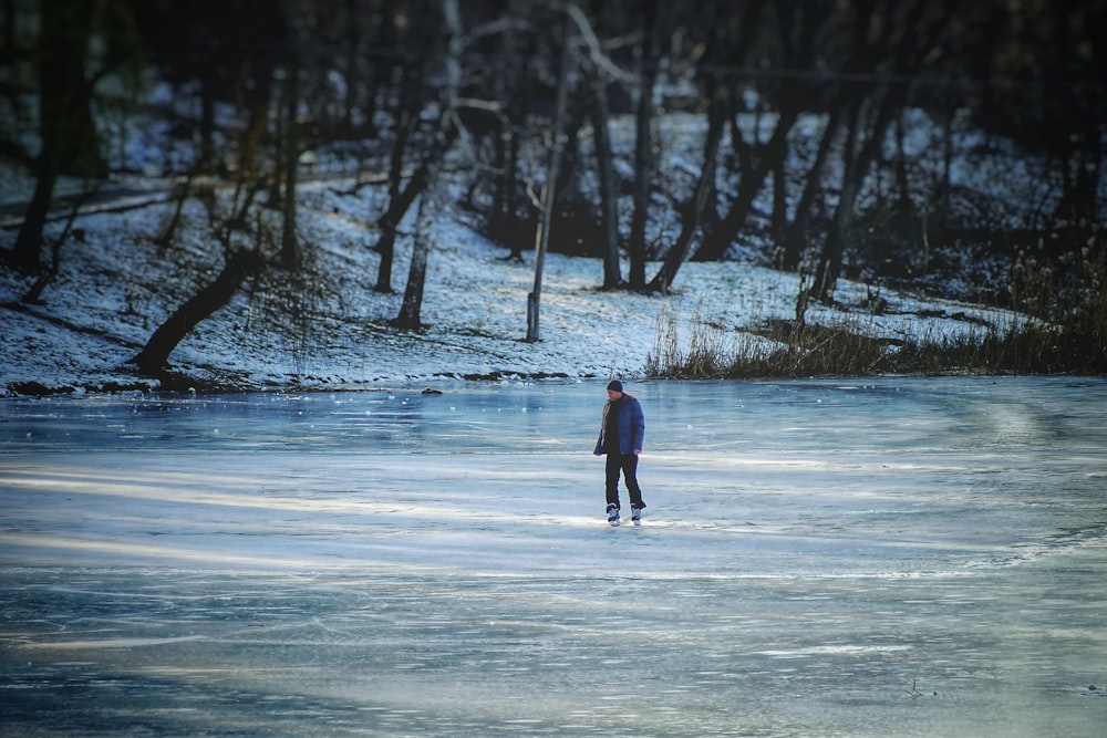 hombre patinando en lago congelado