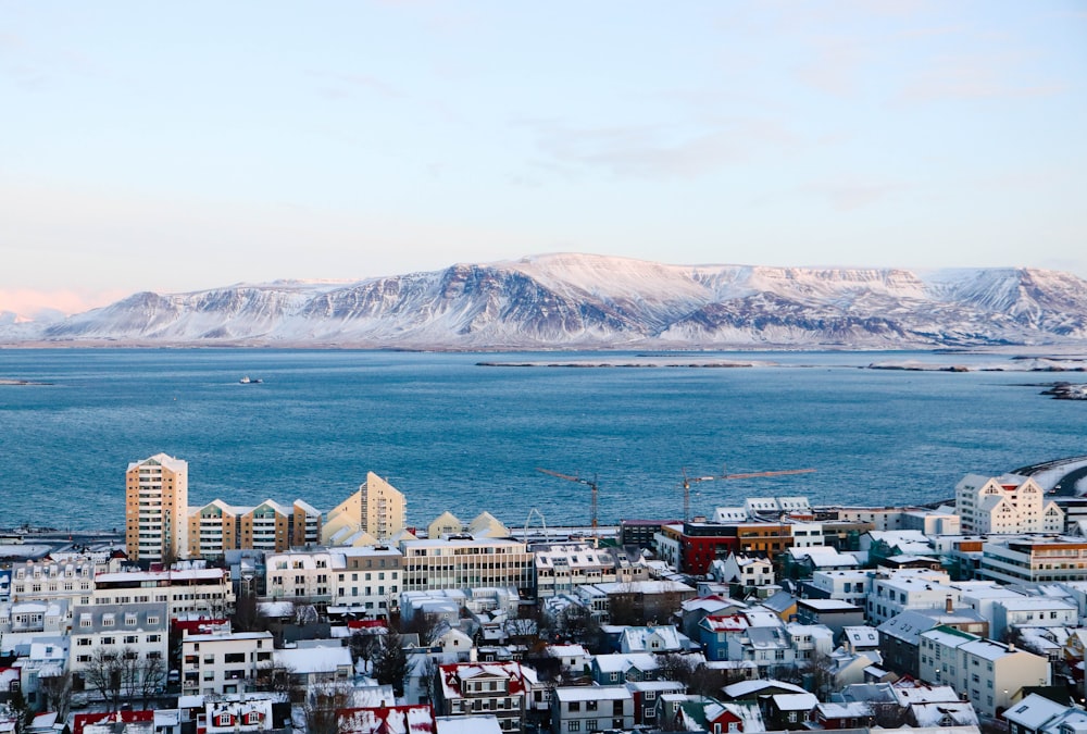 aerial photography of high rise building near sea and mountain during daytime