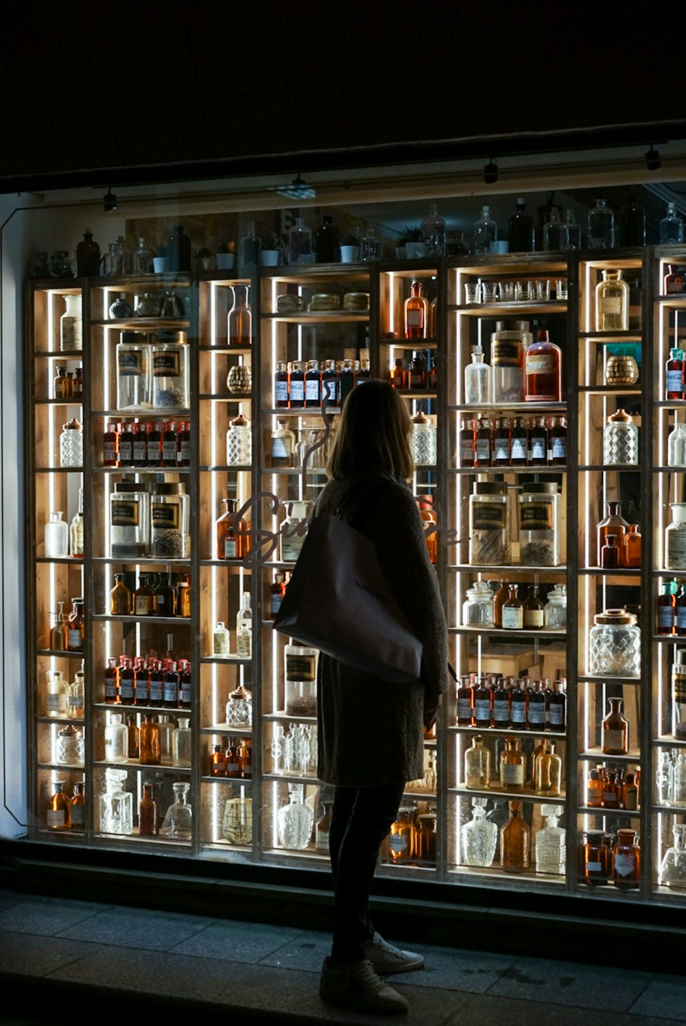 mujer de pie junto a la piedra de licor