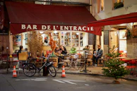A cozy café terrace with locals chatting over coffee in the village center of Portet-sur-Garonne.